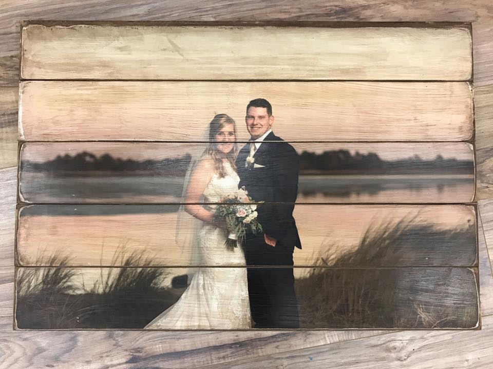 Bride and groom by the water at sunset photo on a five plank wood photo pallet