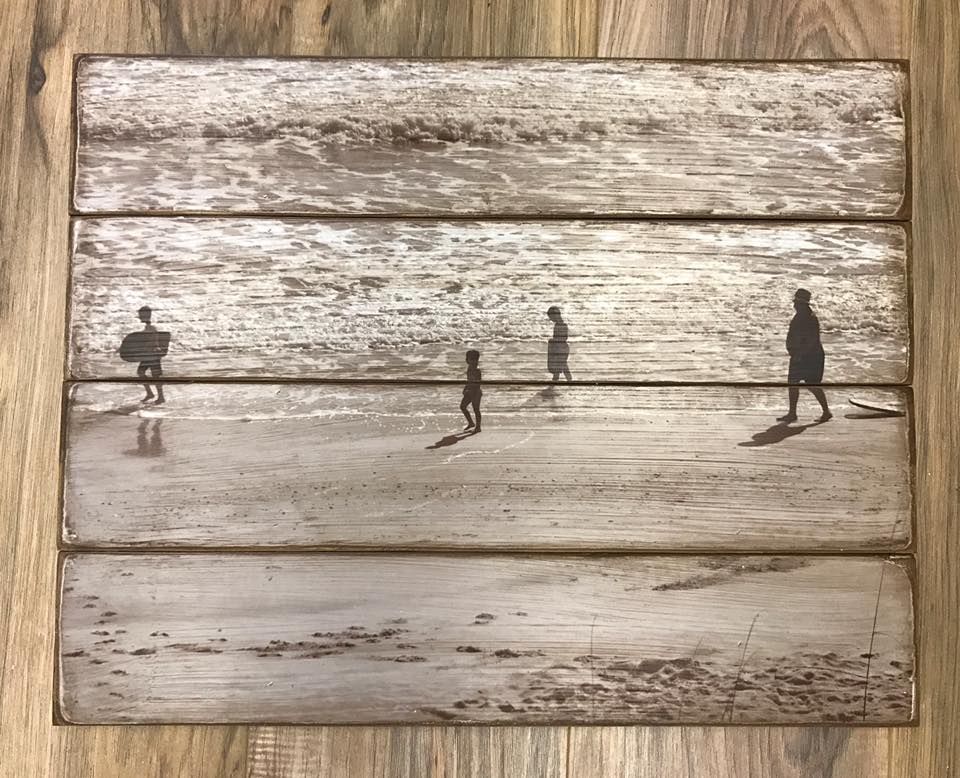 Sepia beach scene with people walking along the shore on a four plank wood photo pallet