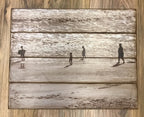 Sepia beach scene with people walking along the shore on a four plank wood photo pallet