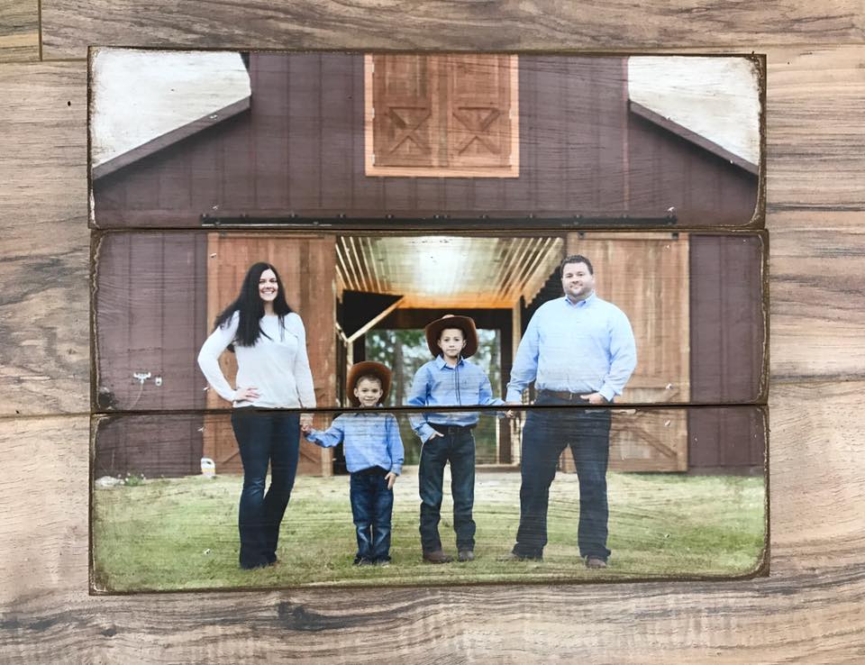 Family of four standing in front of a barn on a three plank wood photo pallet