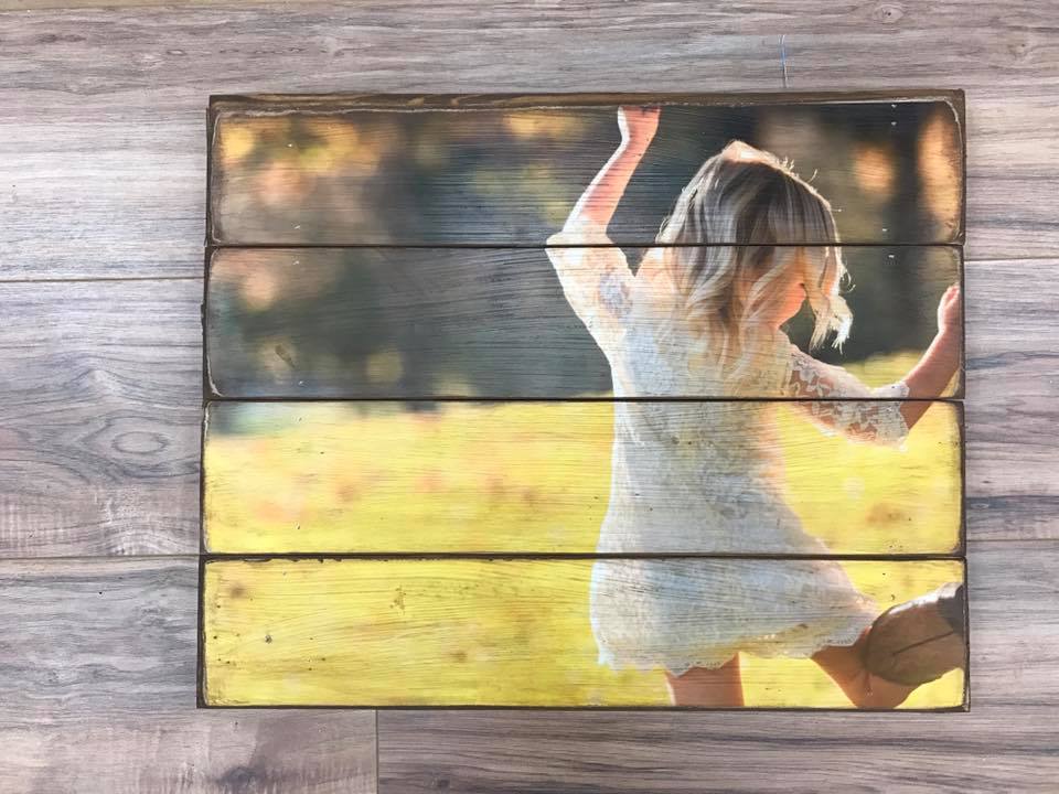 Little girl in a lace dress dancing in a field on a four plank wood photo pallet