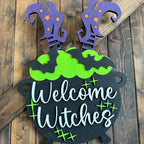 Decorative Halloween sign with 'Welcome Witches' text on a wooden background